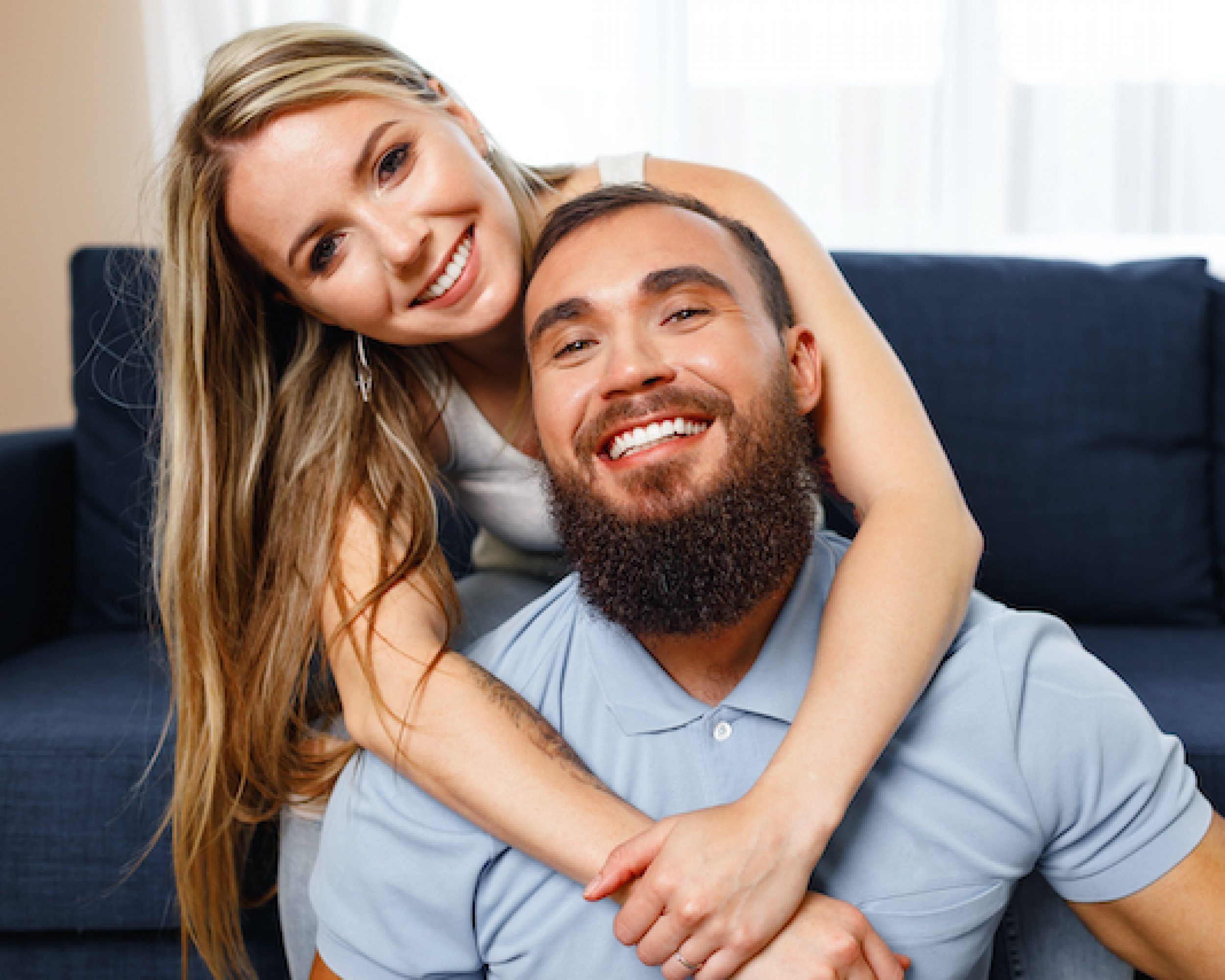 Happy smiling couple sitting on blue sofa in living room